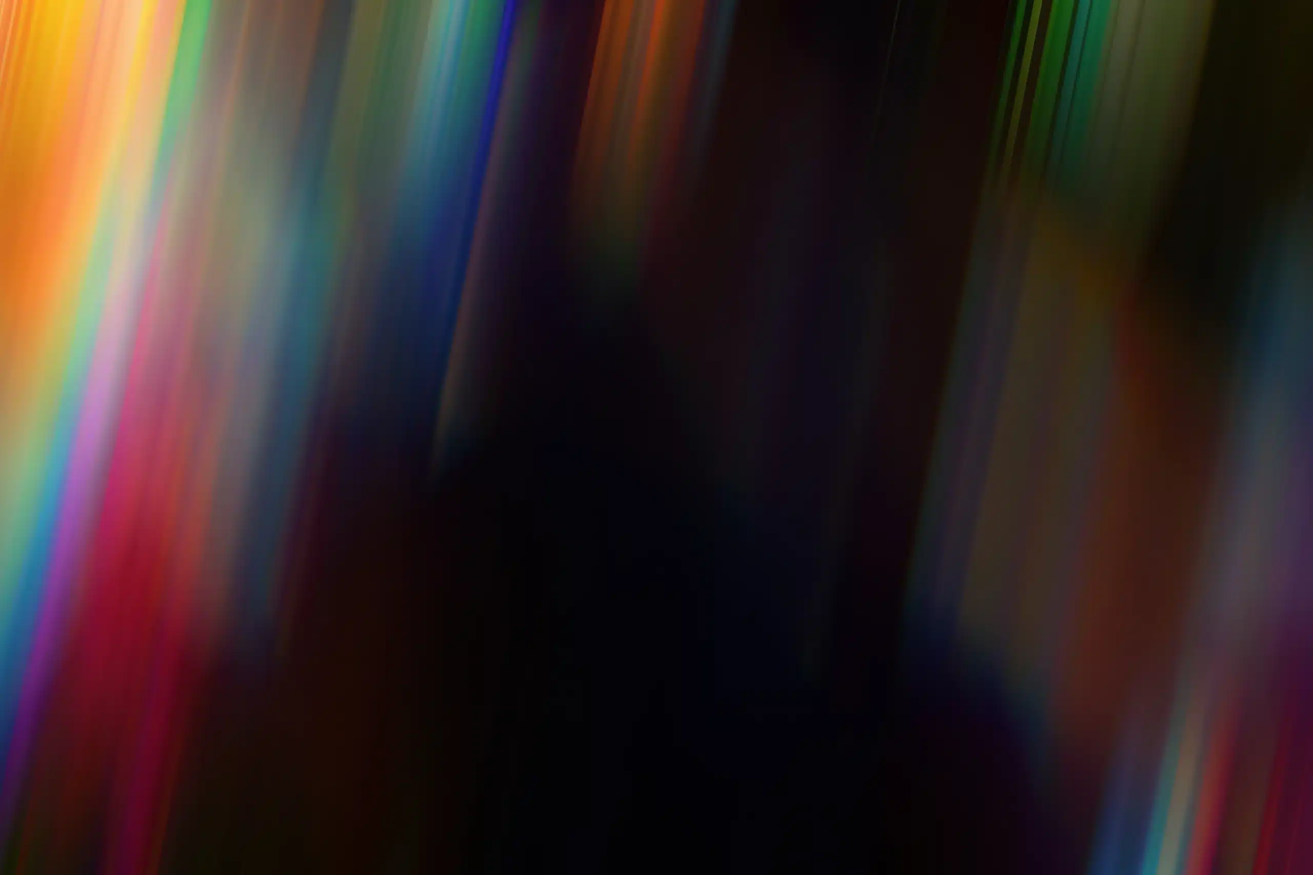 Blurred image with streaks of vibrant colors, including red, blue, green, and yellow, creating an abstract, dynamic effect.
