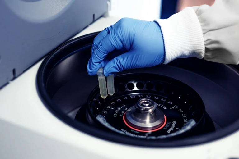 Close up of scientist unloading samples from centrifuge B