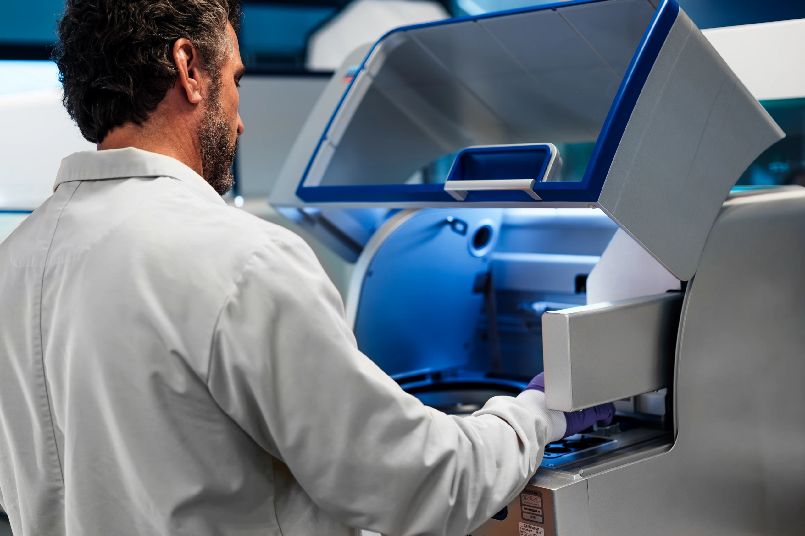 Medium close up of scientist operating a laboratory analyzer machine A