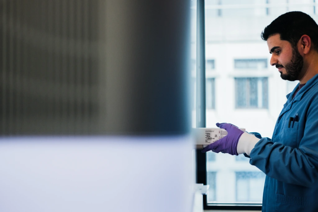 Male scientist operating a touchscreen laboratory analyzer system F