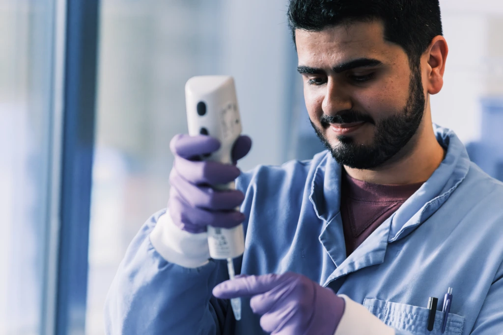 Medium close up of male scientist using electronic pipette C