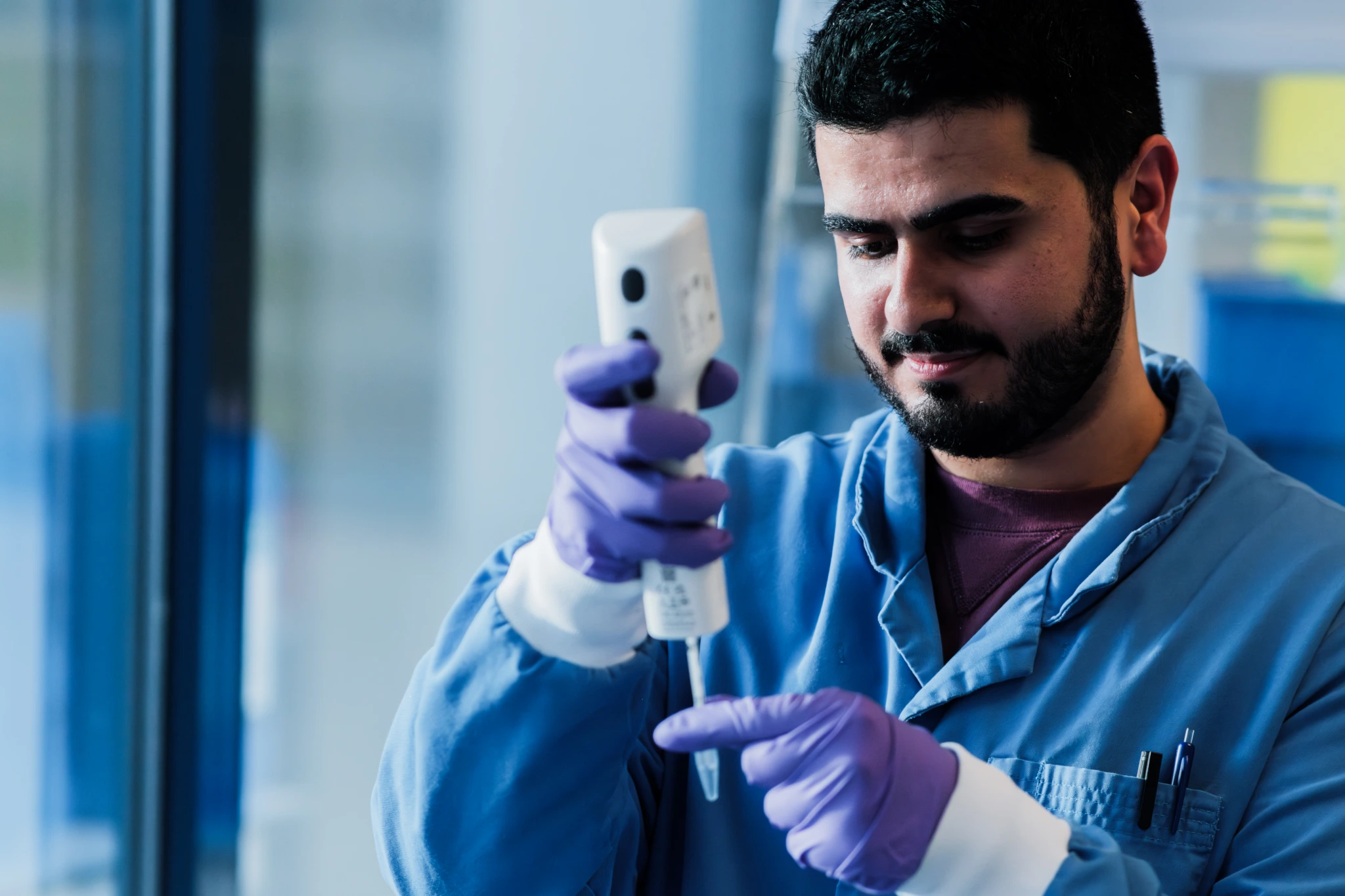 Medium close up of male scientist using electronic pipette D