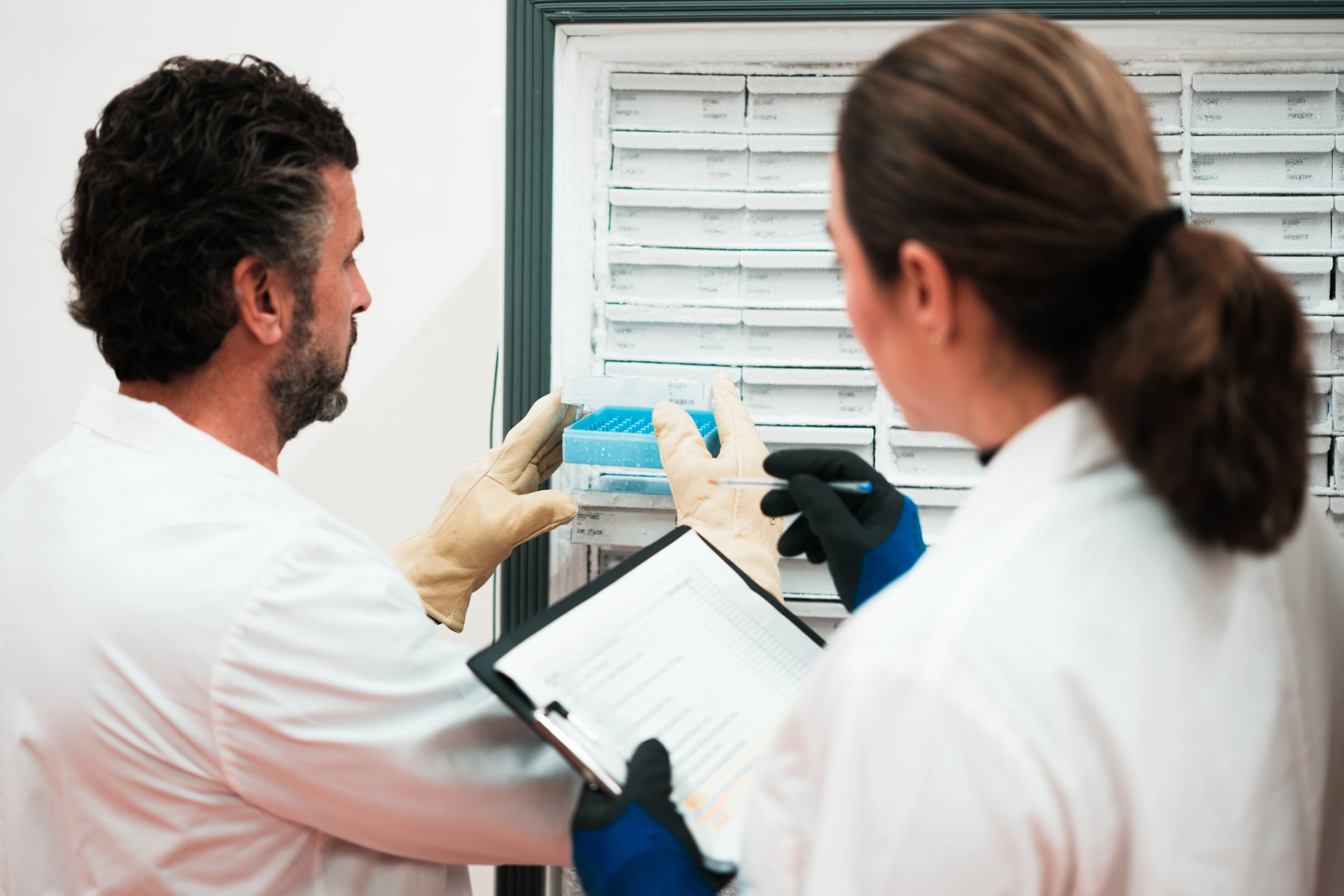 Two scientists reviewing cold storage samples A