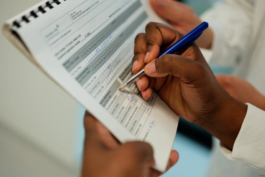 Close up of laboratory checklist and pen in hand