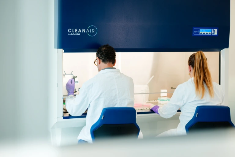 Scientists working inside clean air laboratory cabinet