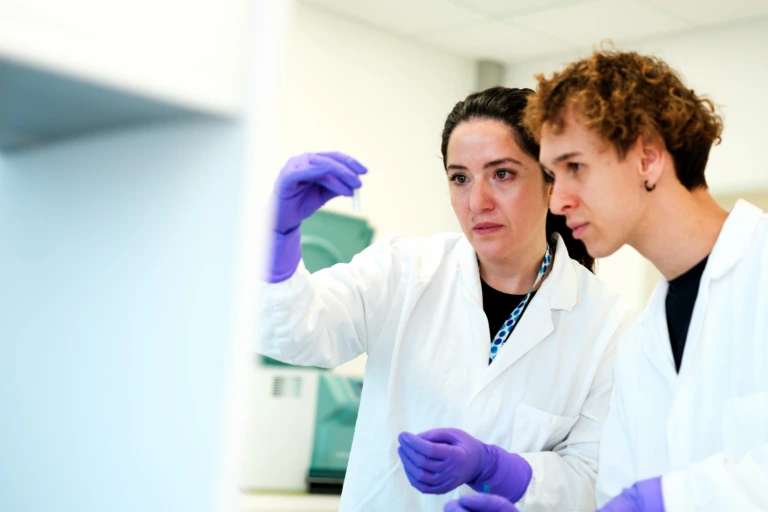 Scientists reviewing sample tube in laboratory