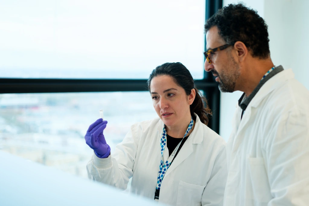 Scientists discussing work together in laboratory workspace