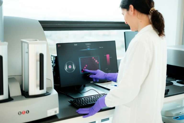 Scientist operating automated laboratory analysis system