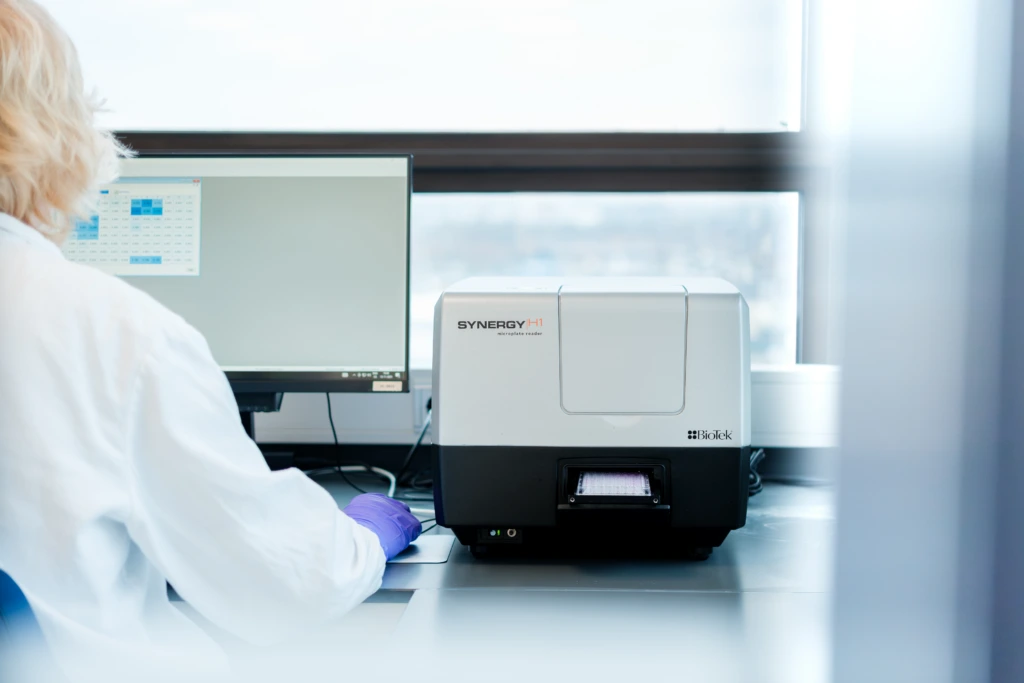 Scientist operating automated genomics analyser from workstation