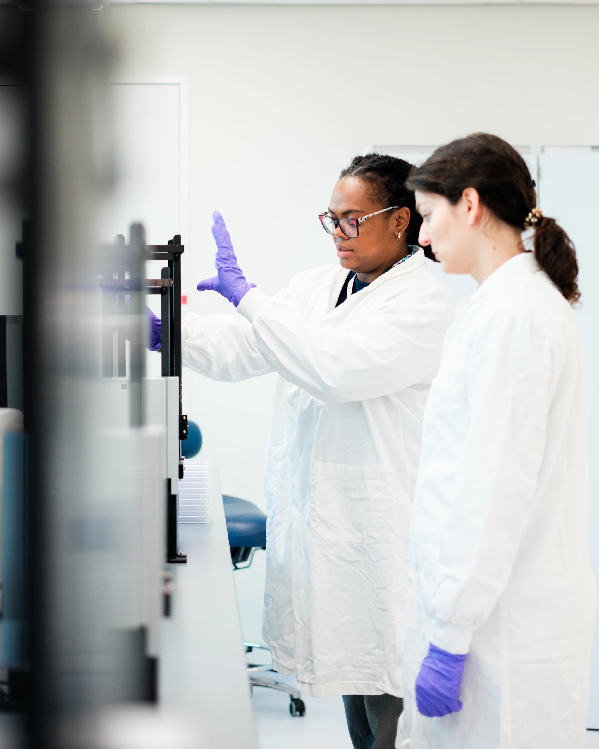 Scientists operating automated liquid handling system