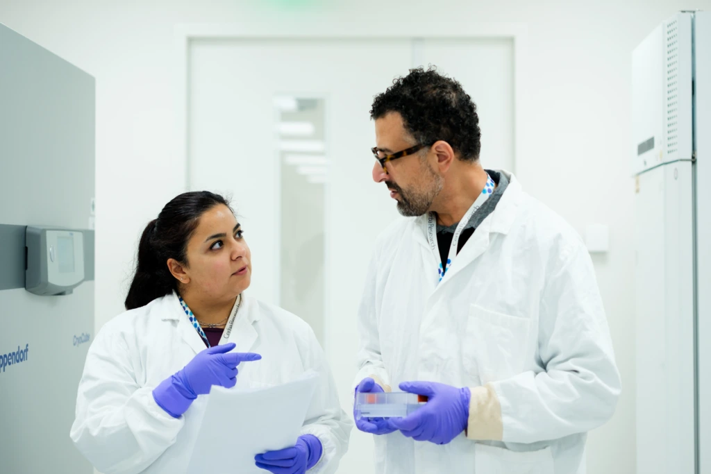 Scientists discussing workflow in laboratory corridor