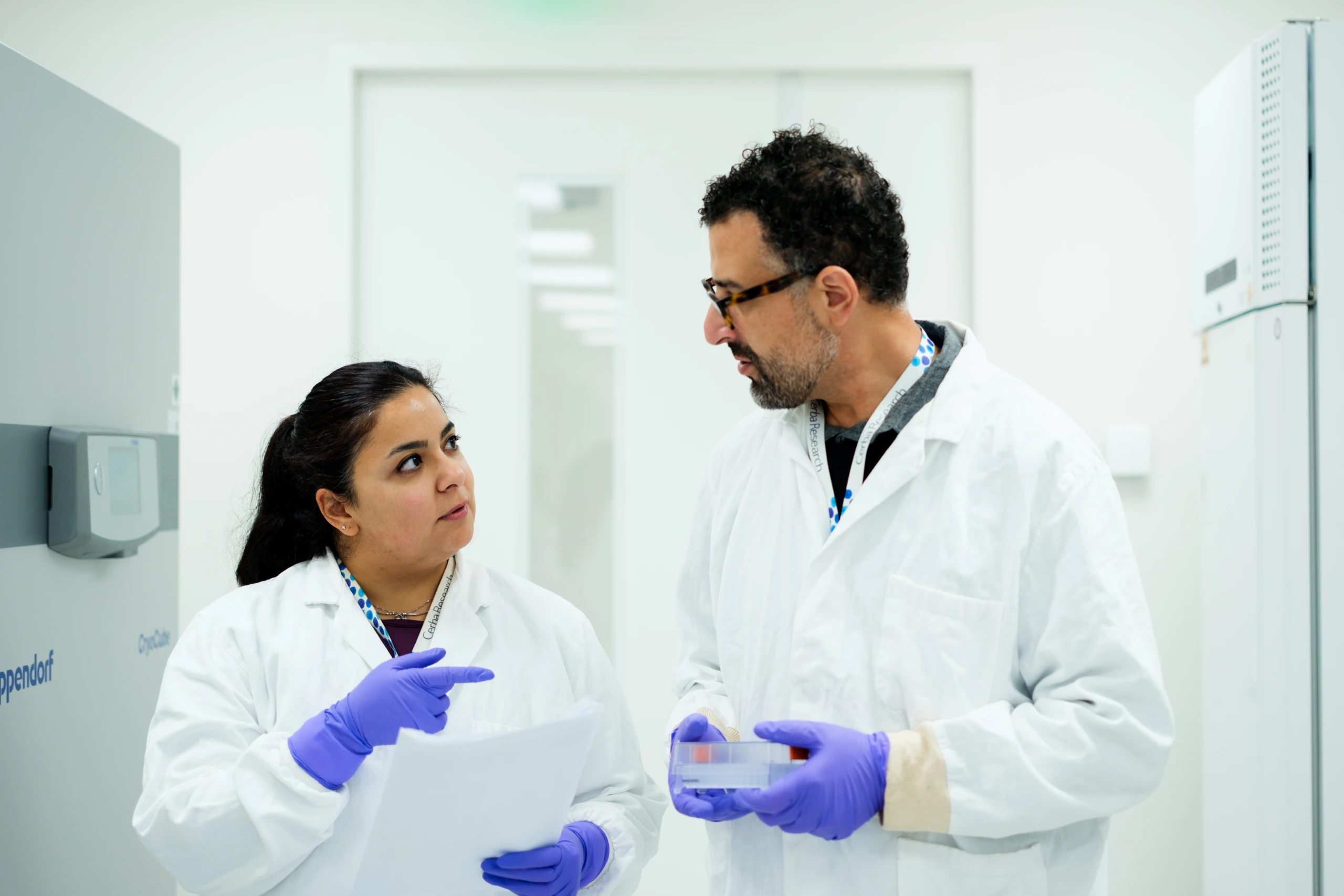 Scientists discussing workflow in laboratory corridor