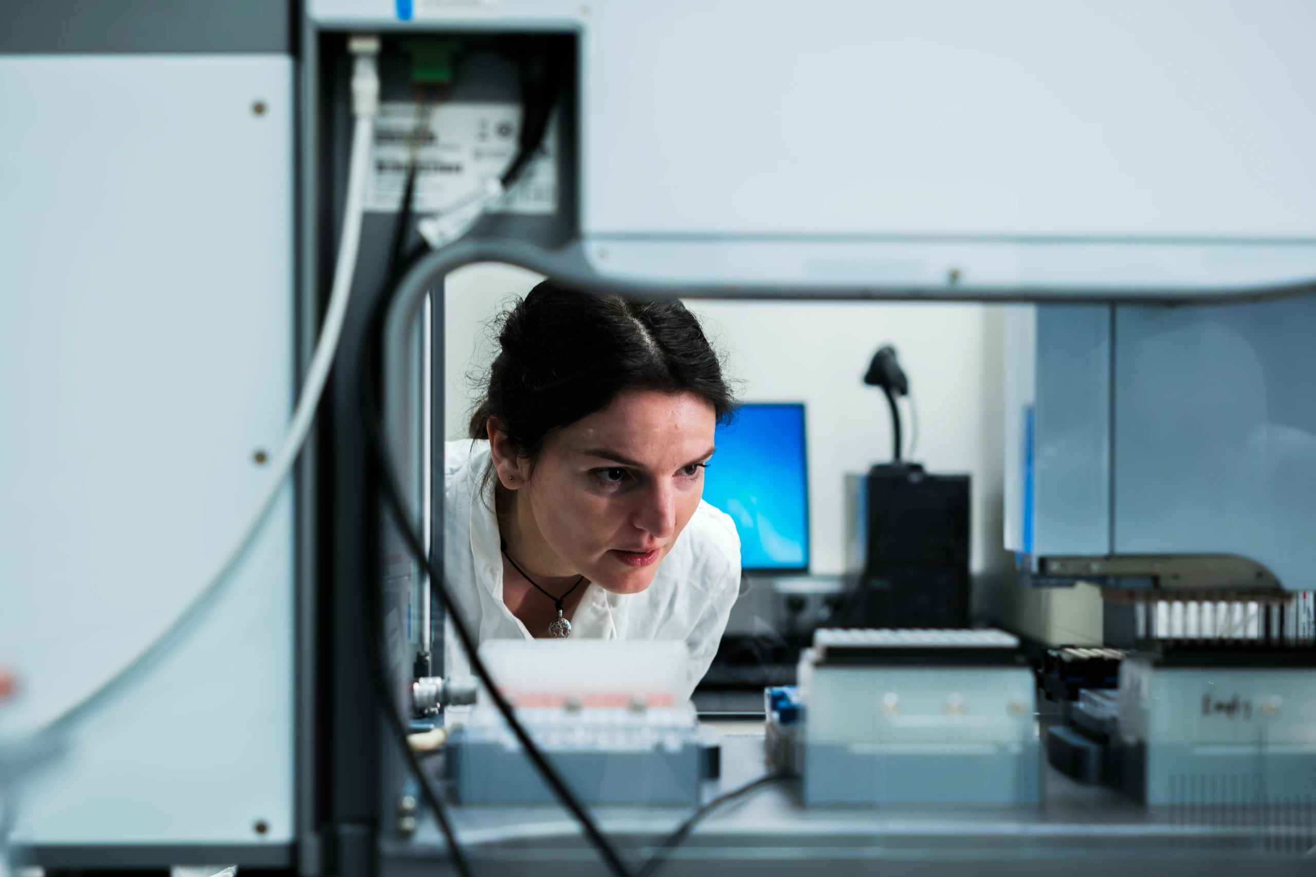 Scientist working beside automated laboratory instrumentation