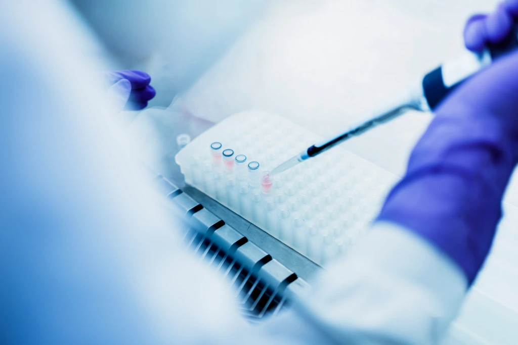 Close up of pipette loading samples into laboratory microplate