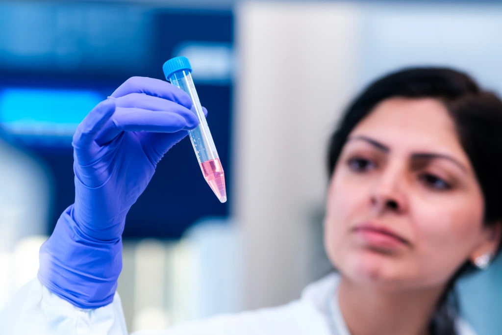Scientist inspecting biological sample tube in laboratory
