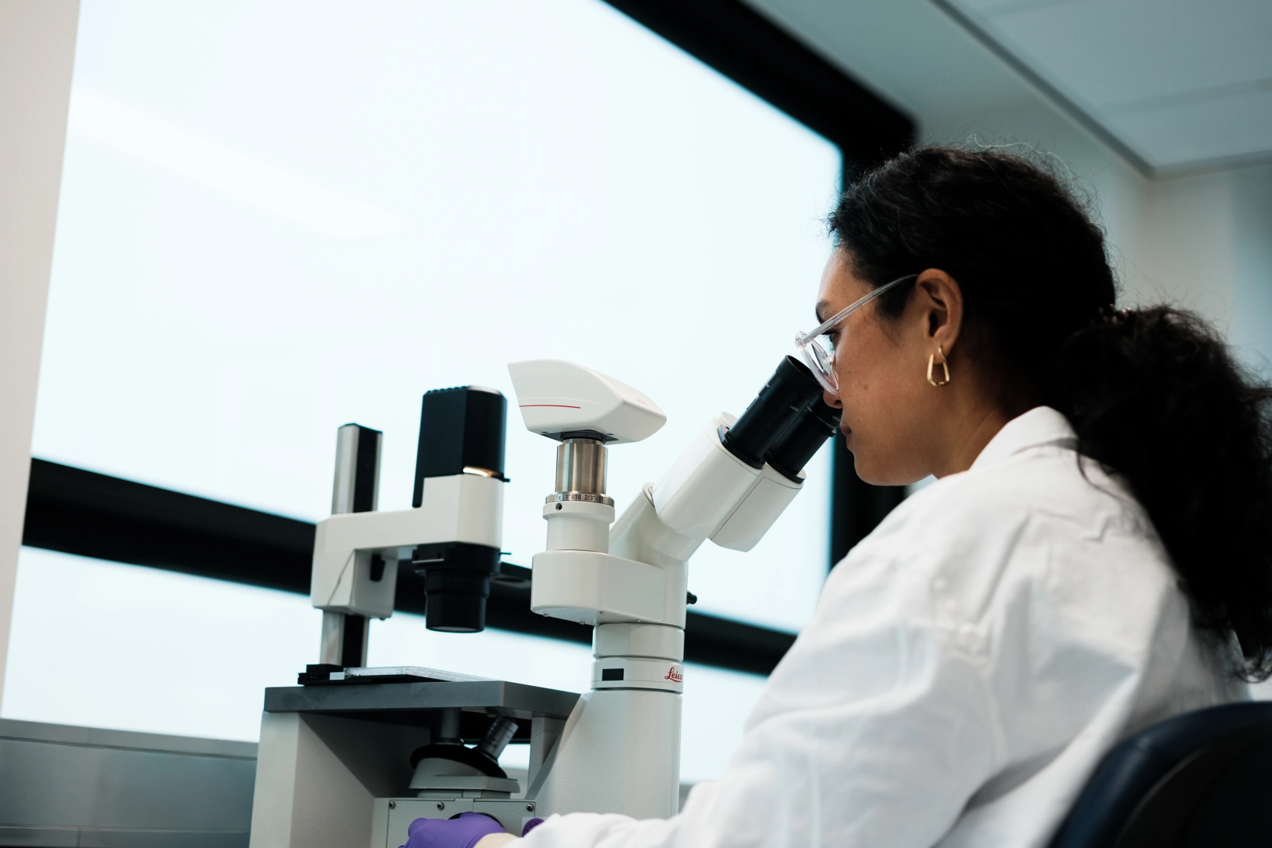 Scientist operating microscope in modern laboratory