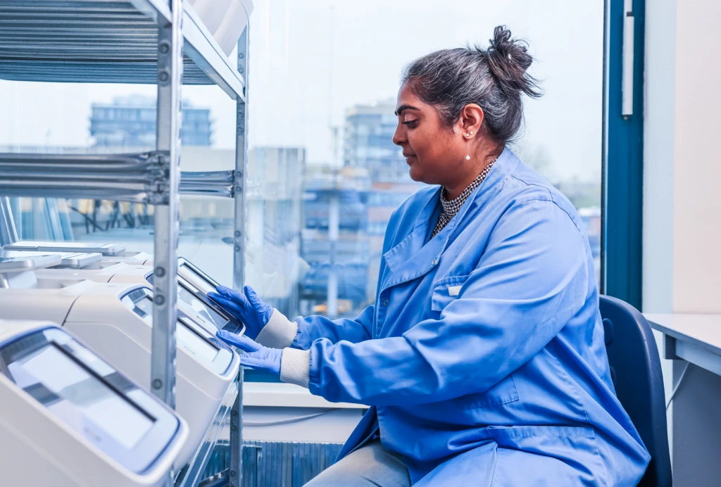 Medium shot of female scientist in blue coat working at laboratory bench