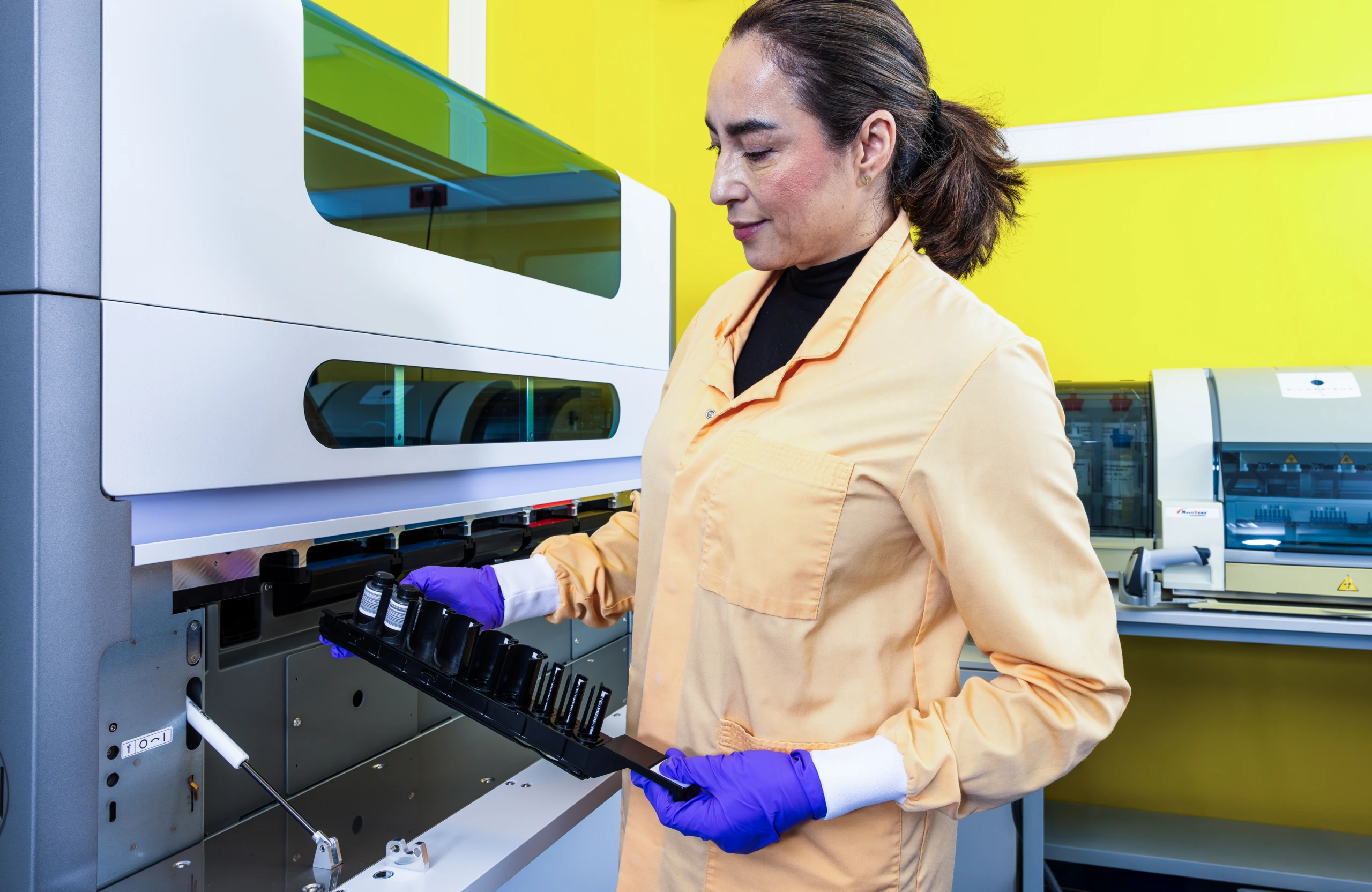 Medium shot of female scientist in yellow coat at laboratory system