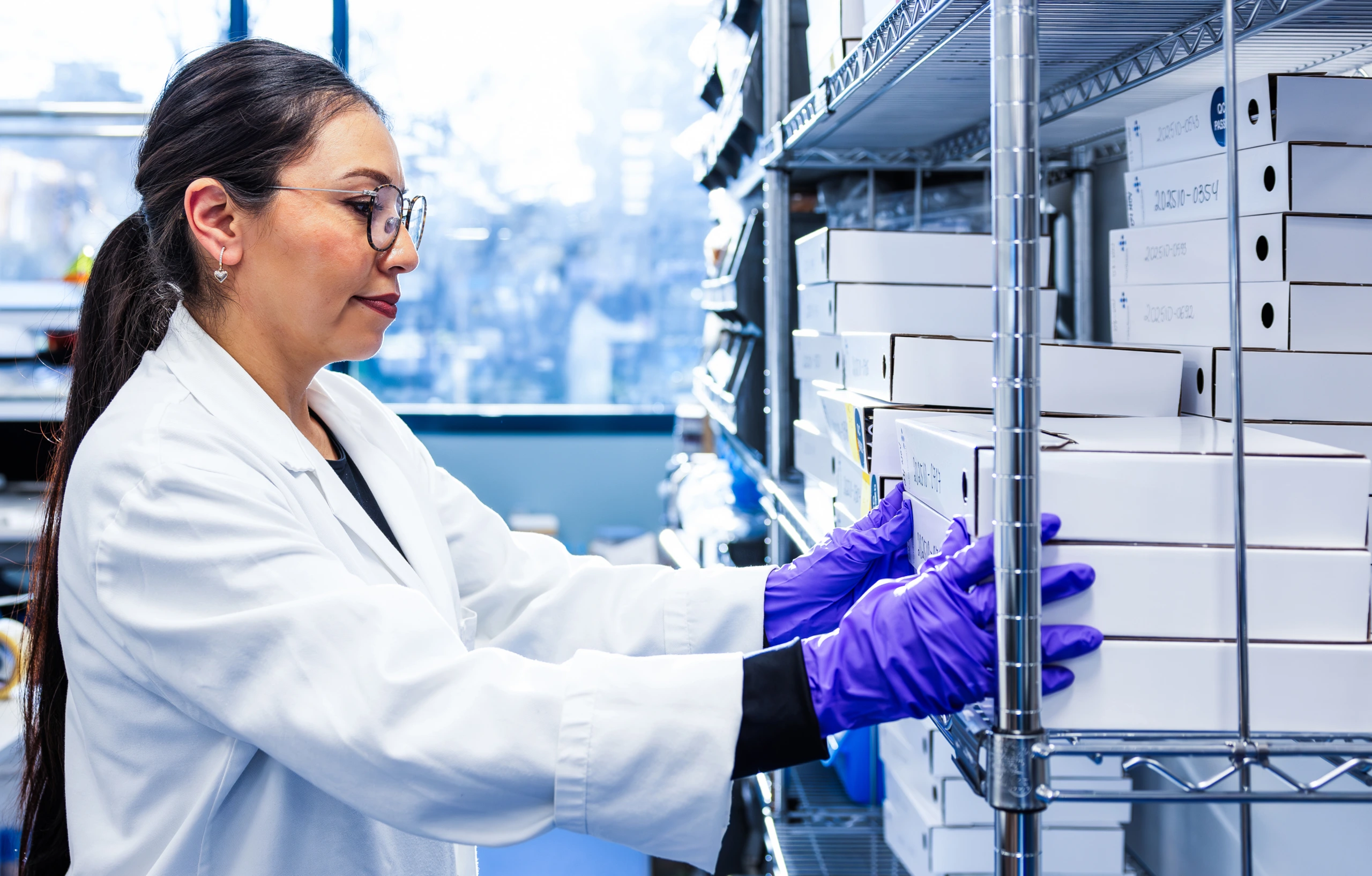 Medium close up of female scientist at laboratory workstation with samples
