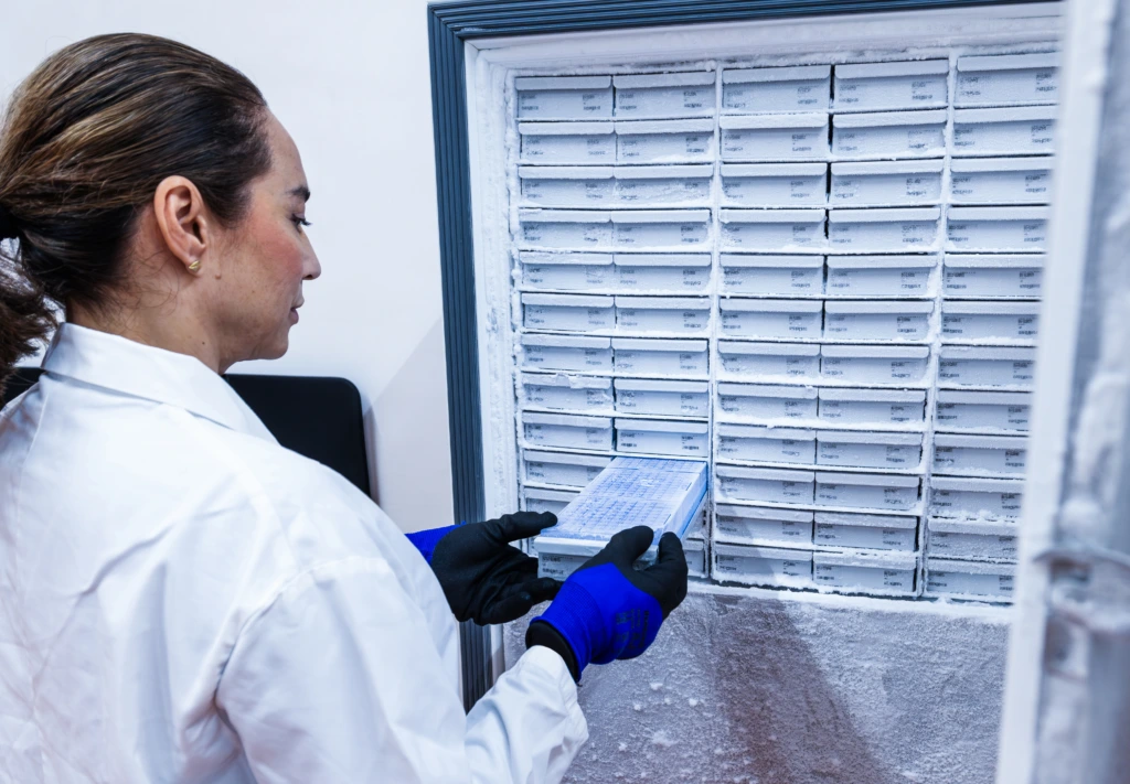 Medium shot of female scientist at laboratory cold storage unit