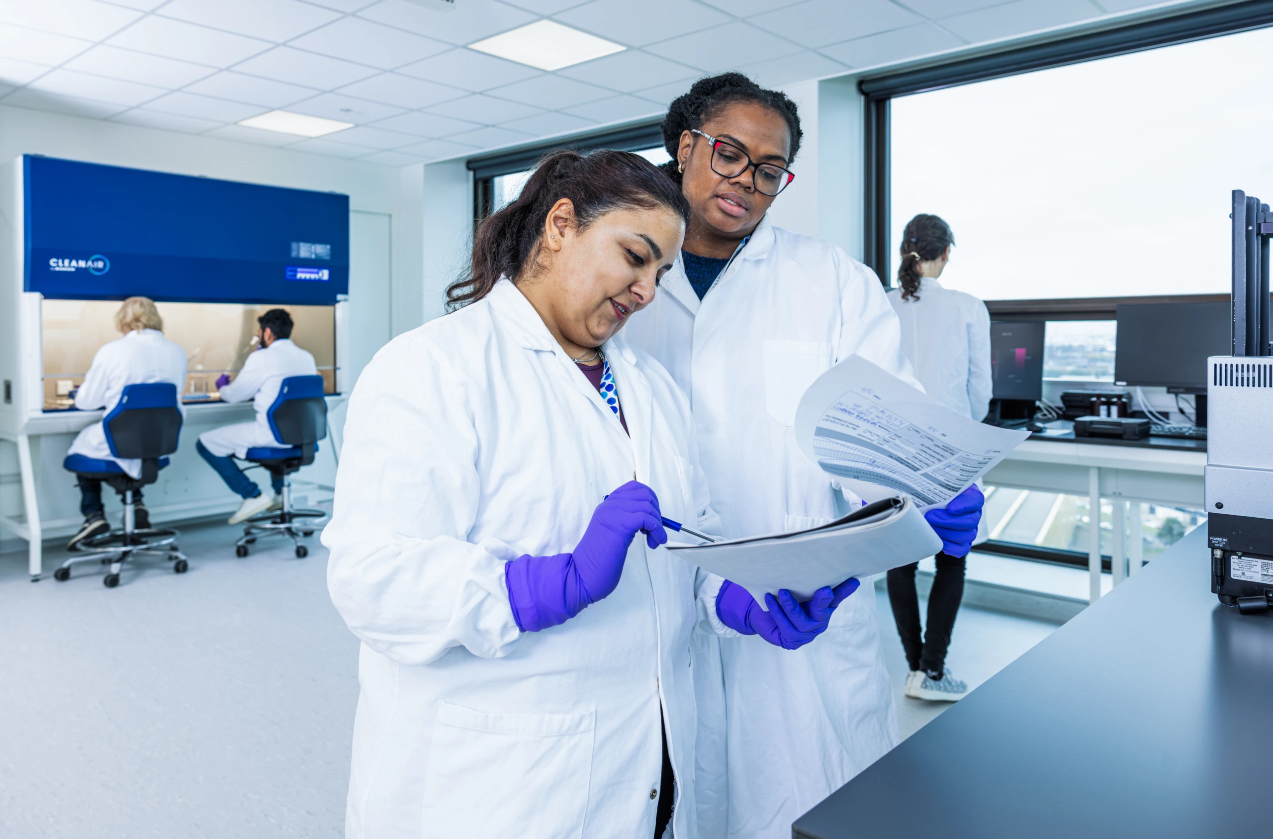 Medium shot of two scientists reviewing laboratory documentation together