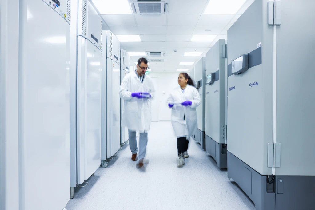 Wide shot of scientist walking alone through bright laboratory facility