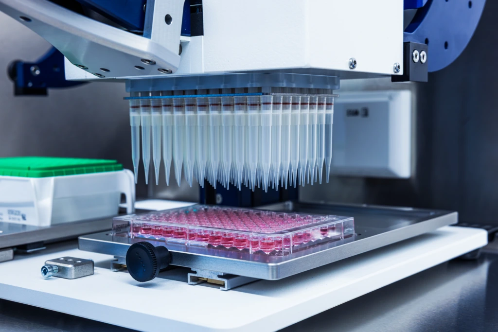 Close up of automated laboratory liquid handling system with well plates