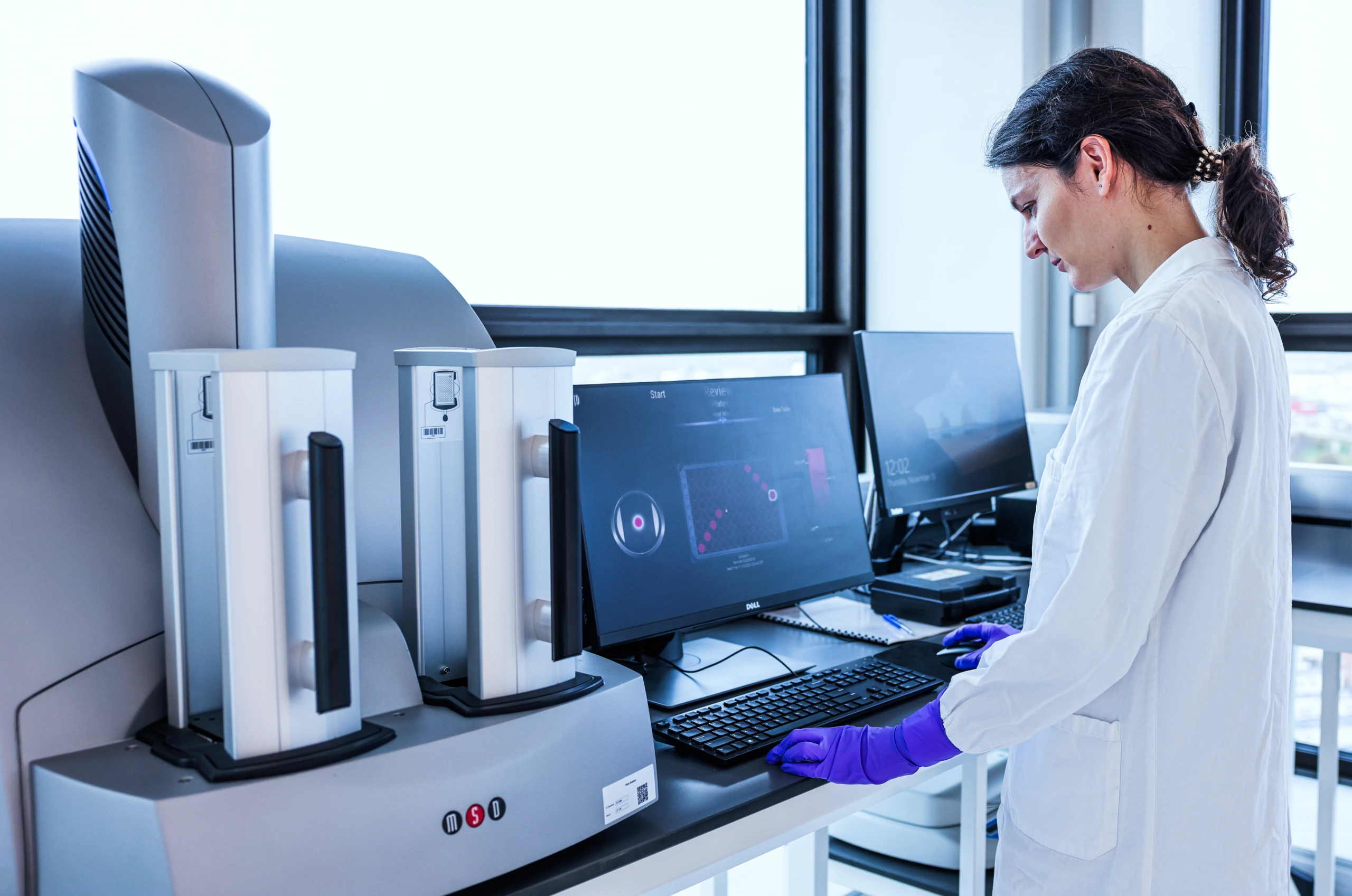 Medium shot of female scientist at laboratory workstation with computer