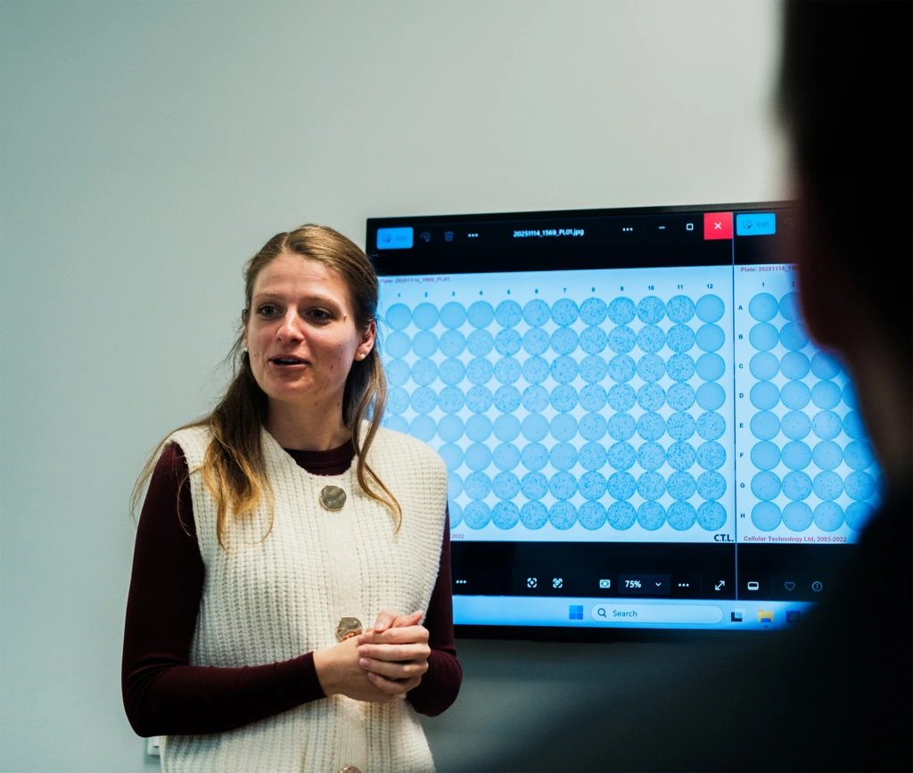 Scientist presenting microplate analysis on digital display