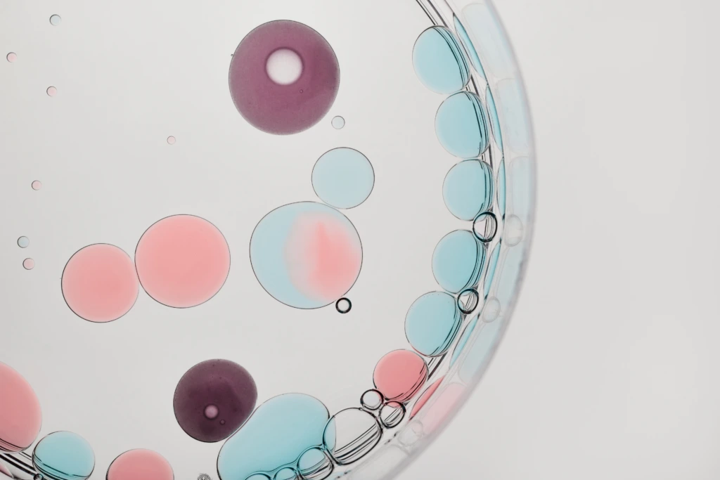 Liquid,Droplets,In,Multiple,Colors,Floating,And,Merging,Inside,Clear